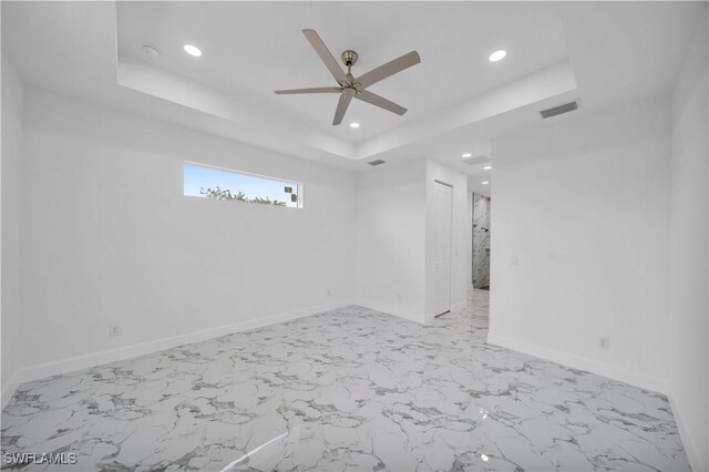 unfurnished room with visible vents, baseboards, a raised ceiling, ceiling fan, and recessed lighting