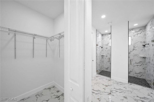 walk in closet featuring marble finish floor