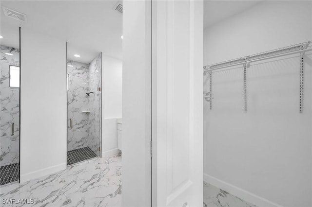 bathroom featuring a walk in closet, marble finish floor, visible vents, and a marble finish shower