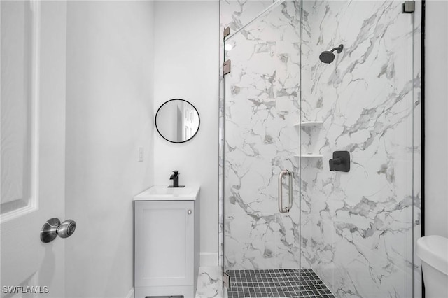 full bathroom featuring toilet, vanity, and a marble finish shower