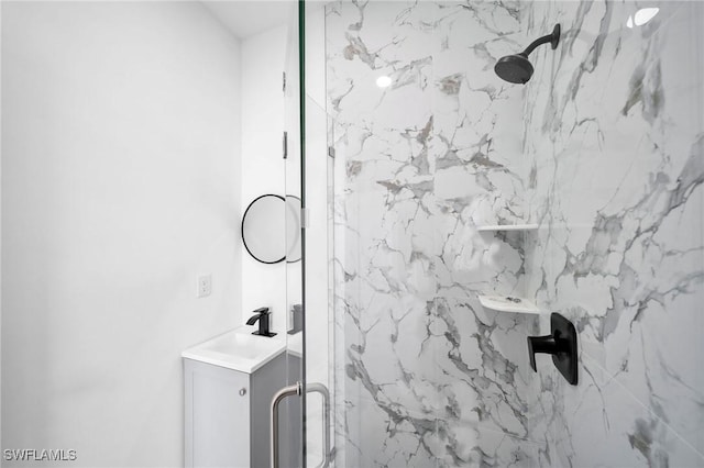 bathroom with a marble finish shower and vanity