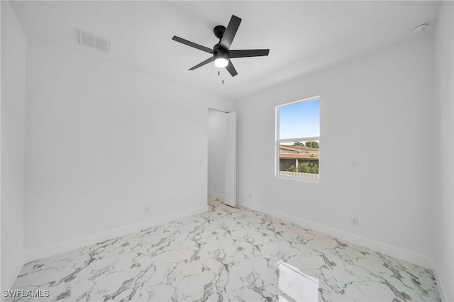 empty room with marble finish floor, baseboards, visible vents, and ceiling fan