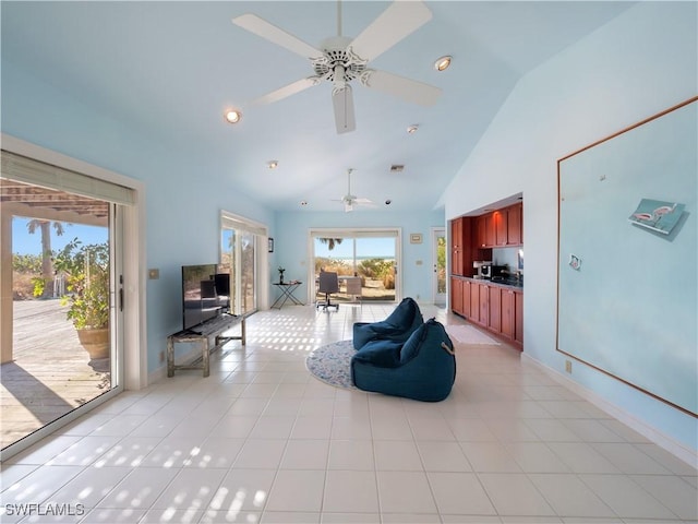 living room with baseboards, high vaulted ceiling, ceiling fan, and light tile patterned flooring