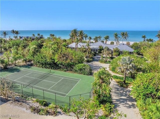 view of tennis court with a water view