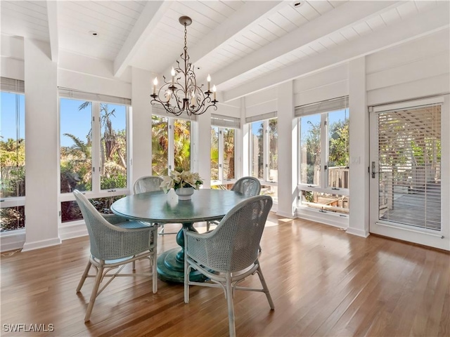 sunroom featuring a chandelier and beamed ceiling