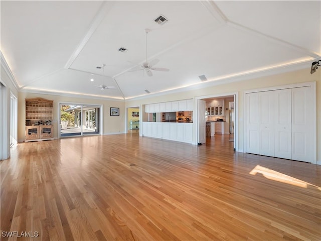 unfurnished living room with lofted ceiling, a ceiling fan, visible vents, and light wood-style floors