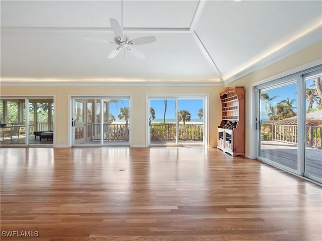 unfurnished living room featuring lofted ceiling, a healthy amount of sunlight, and wood finished floors