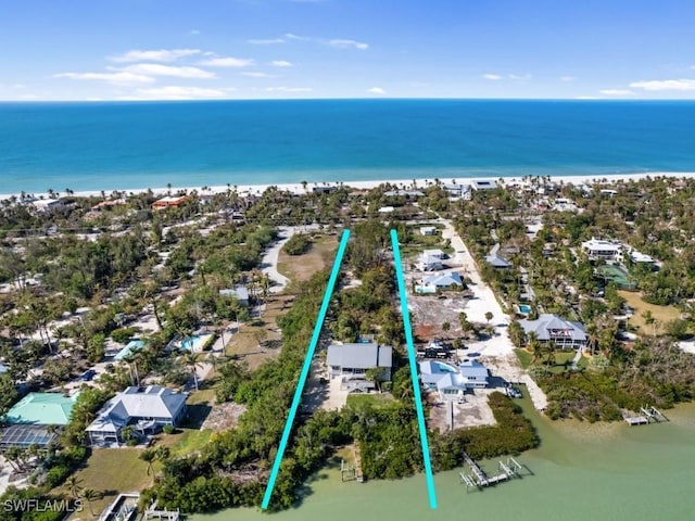 birds eye view of property featuring a water view and a beach view