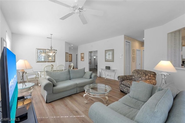 living room featuring light wood-type flooring and ceiling fan with notable chandelier