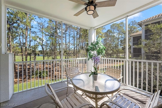 sunroom with a water view and ceiling fan