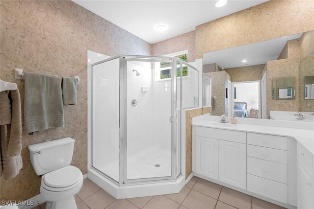 ensuite bathroom with tile patterned floors, toilet, and wallpapered walls