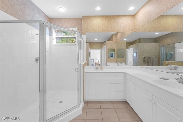 bathroom featuring a sink, a stall shower, double vanity, and tile patterned flooring