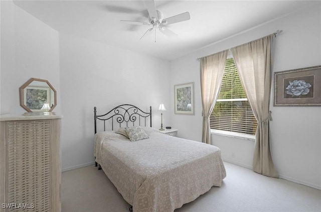 carpeted bedroom featuring baseboards and a ceiling fan