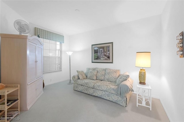 carpeted living area featuring baseboards