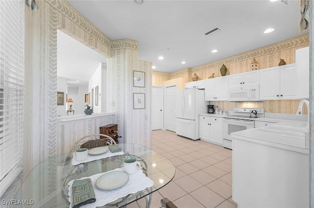 kitchen with visible vents, white cabinetry, white appliances, light countertops, and light tile patterned floors