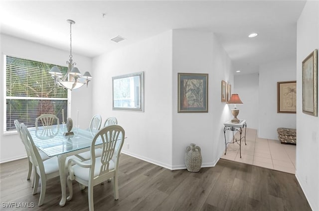 dining area with a notable chandelier, recessed lighting, wood finished floors, and baseboards