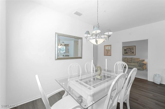 dining space with an inviting chandelier, dark wood-style floors, visible vents, and baseboards