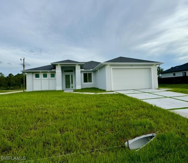 prairie-style house with a garage, driveway, a front lawn, and stucco siding