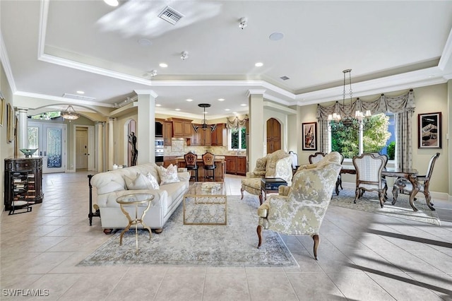 living room featuring arched walkways, a chandelier, a raised ceiling, and decorative columns