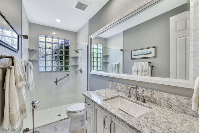 full bath with plenty of natural light, a shower stall, toilet, and visible vents