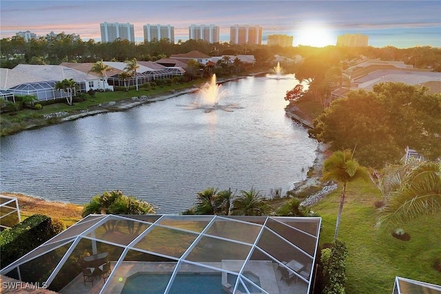 aerial view at dusk featuring a water view