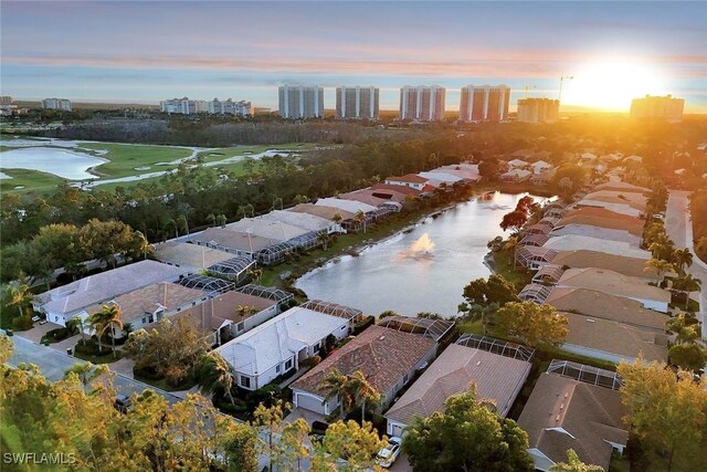 aerial view at dusk featuring a water view