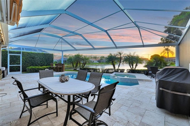 view of patio / terrace featuring a lanai, outdoor dining area, a water view, and a pool with connected hot tub