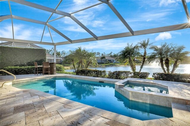 view of swimming pool with glass enclosure, a patio, a water view, and a pool with connected hot tub