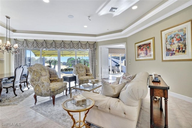 living room featuring an inviting chandelier, a tray ceiling, baseboards, and visible vents