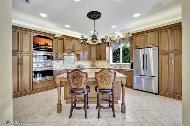 kitchen featuring light stone counters, brown cabinets, stainless steel appliances, and a sink