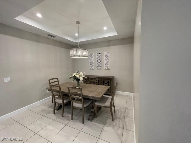 dining area featuring light tile patterned floors, visible vents, baseboards, and a tray ceiling