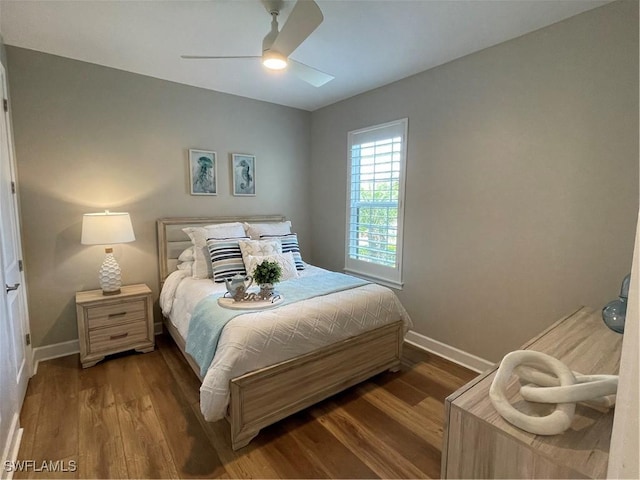 bedroom with a ceiling fan, baseboards, and wood finished floors