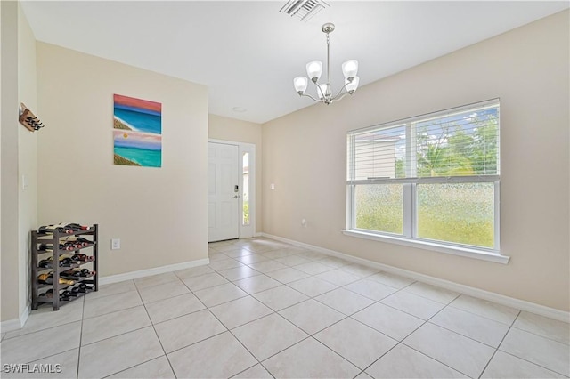 unfurnished room with a notable chandelier, light tile patterned floors, visible vents, and baseboards