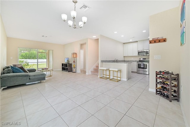 kitchen with light countertops, appliances with stainless steel finishes, open floor plan, white cabinets, and a kitchen breakfast bar