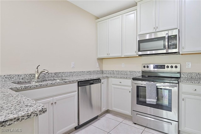 kitchen with light tile patterned floors, white cabinetry, stainless steel appliances, and a sink