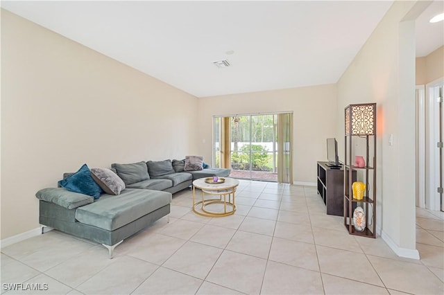 living room with visible vents, vaulted ceiling, baseboards, and light tile patterned floors