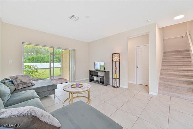 living room featuring stairway, baseboards, light tile patterned floors, and visible vents