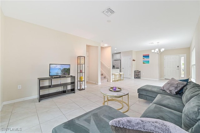 living room featuring baseboards, visible vents, an inviting chandelier, stairs, and light tile patterned flooring