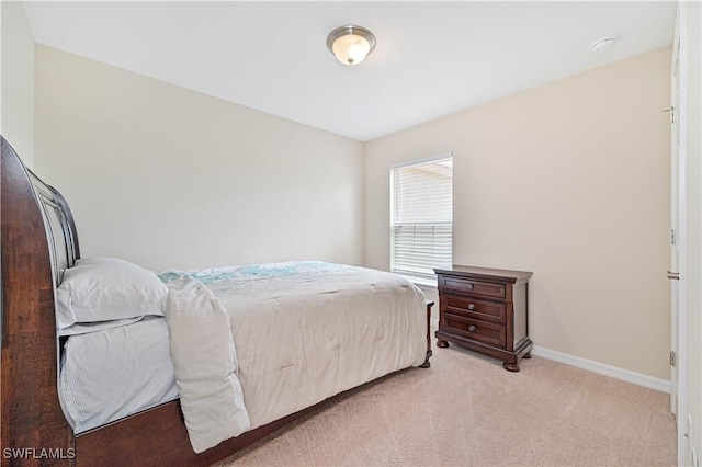 bedroom featuring baseboards and light colored carpet