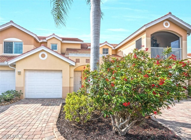 view of front of home featuring stucco siding, decorative driveway, a garage, and a tile roof