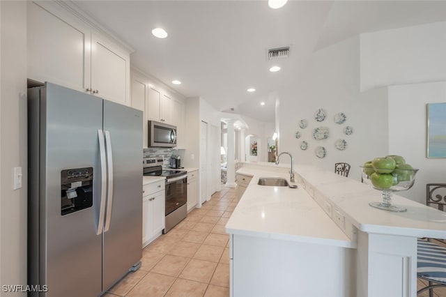 kitchen featuring visible vents, a sink, white cabinetry, appliances with stainless steel finishes, and light countertops