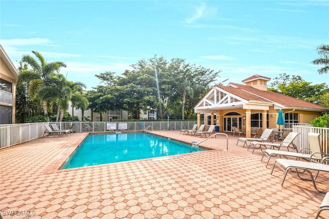 pool with a patio area and fence