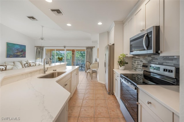 kitchen featuring visible vents, backsplash, stainless steel appliances, and a sink