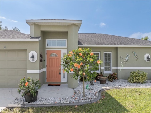 entrance to property with a garage, a shingled roof, and stucco siding