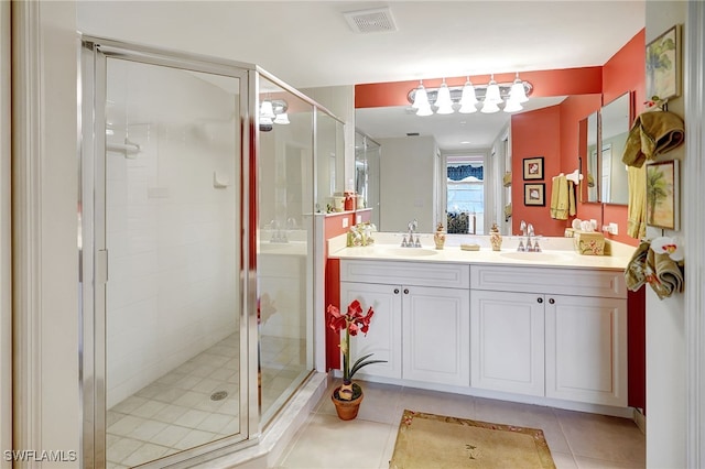 full bathroom with double vanity, visible vents, a sink, a shower stall, and tile patterned floors