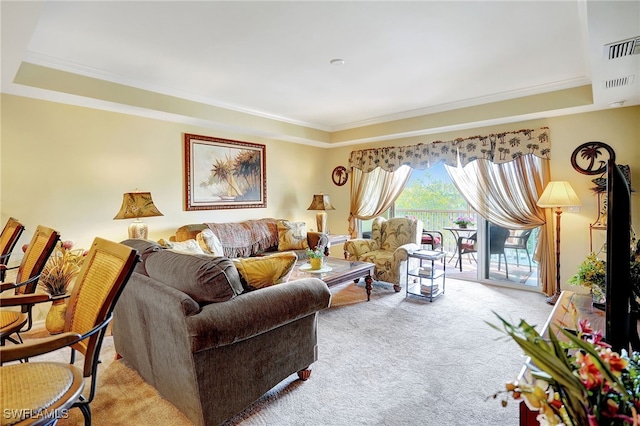 living area featuring a tray ceiling, light colored carpet, and crown molding