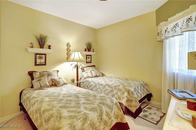 bedroom featuring carpet and baseboards