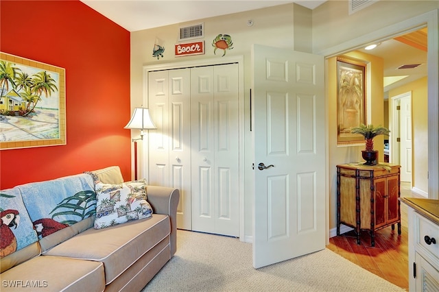 living area with visible vents, light carpet, and baseboards