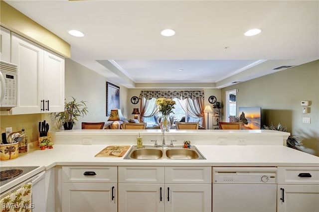 kitchen with white appliances, open floor plan, light countertops, white cabinetry, and a sink