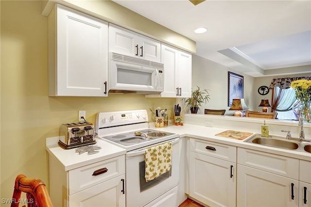 kitchen featuring white appliances, light countertops, a sink, and white cabinetry